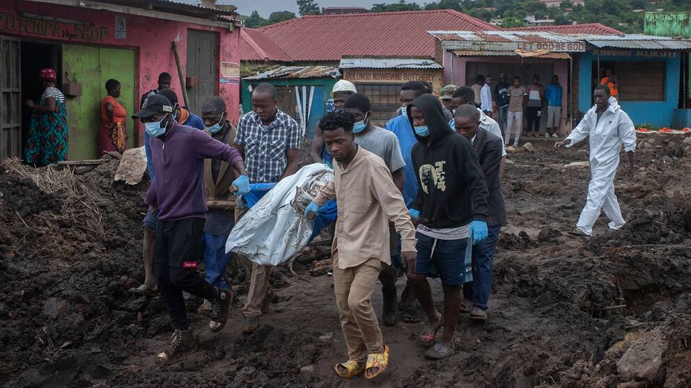 Några boende i staden Blantyre, Malawi, bär iväg personer som fallit offer för ett jordskred i samband med stormen Freddy.