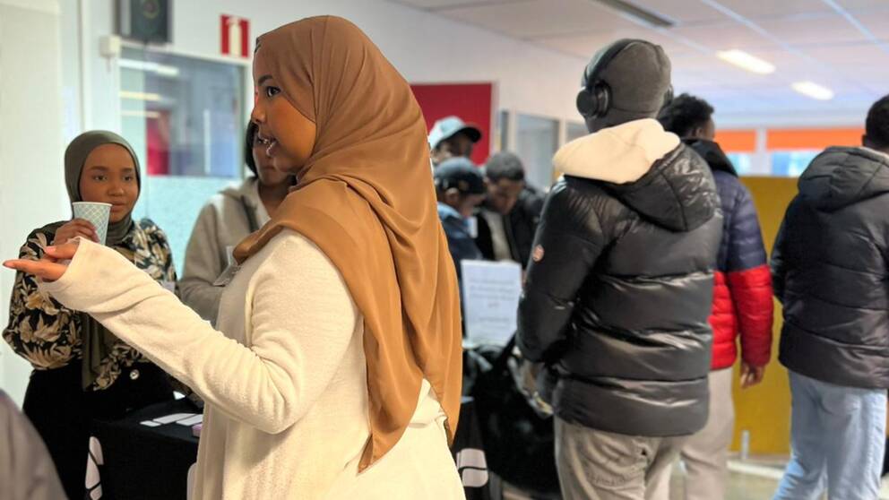 Personer står och minglar, både män och kvinnor.