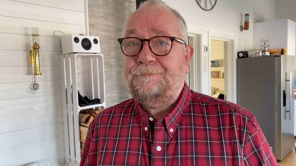 Bilden är ett porträtt av advokat Per Näslund. Han tittar in i kameran och står utomhus. Han har glasögon och en rutig skjorta på sig.