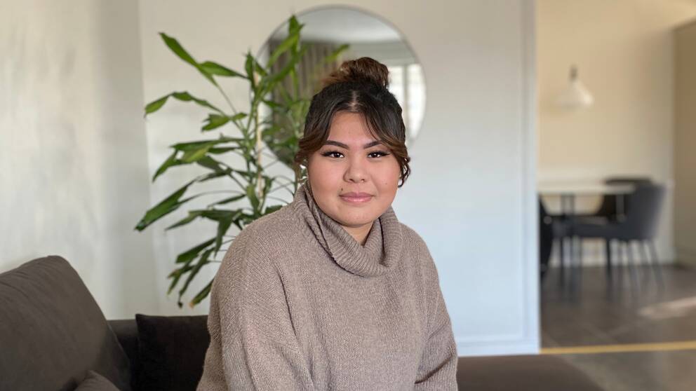17-åriga Mursal Baig från Sandviken sitter i en soffa i hemmet och tittar in i kameran.