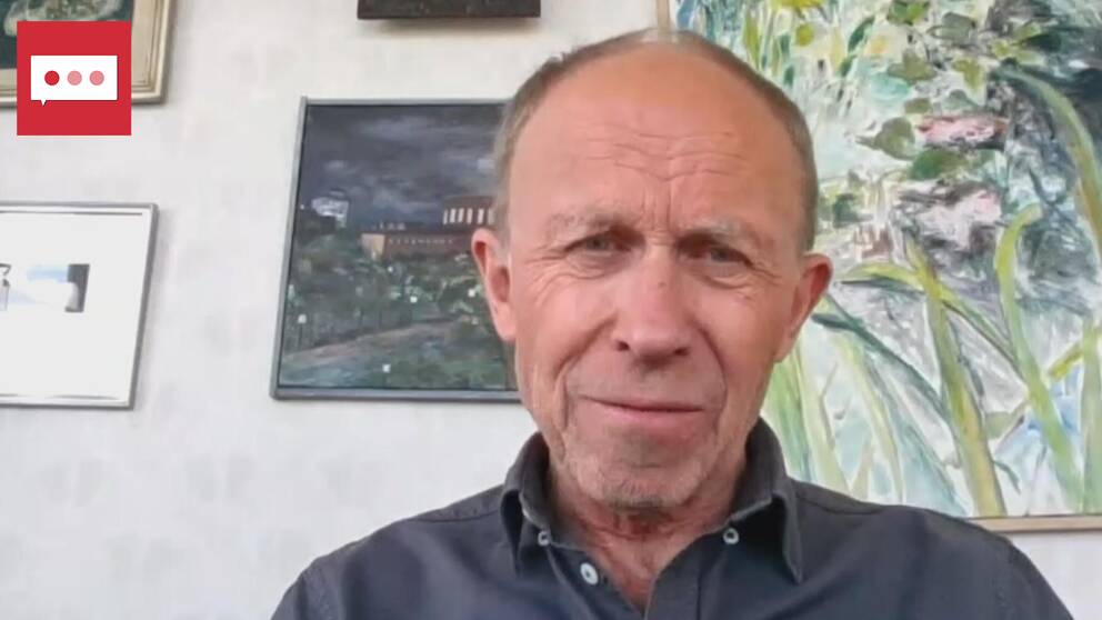 Forskaren Max Strandberg sitter framför en vägg med tavlor.