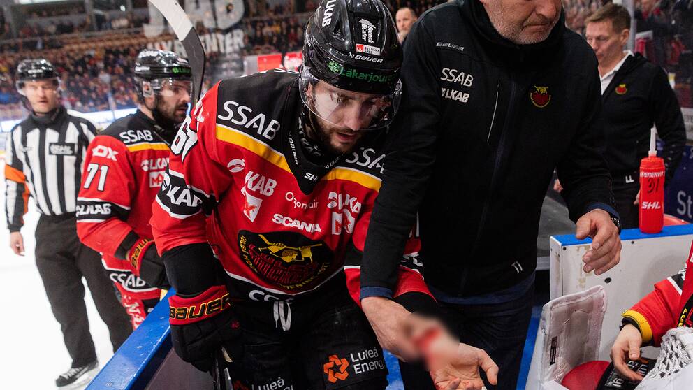 Konstantin Komarek leddes ut efter att ha blivit skuren över handleden.