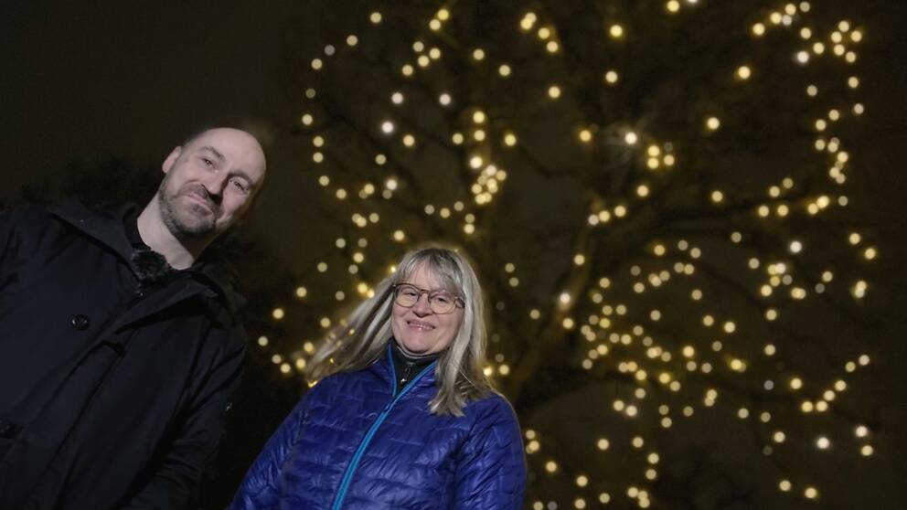 En och man en kvinna framför ett upplyst träd i Lundagård, Lund. Det är Susanne Åkesson och Johan Eklöf.