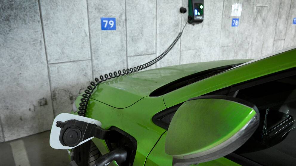 En grön elbil på laddning.