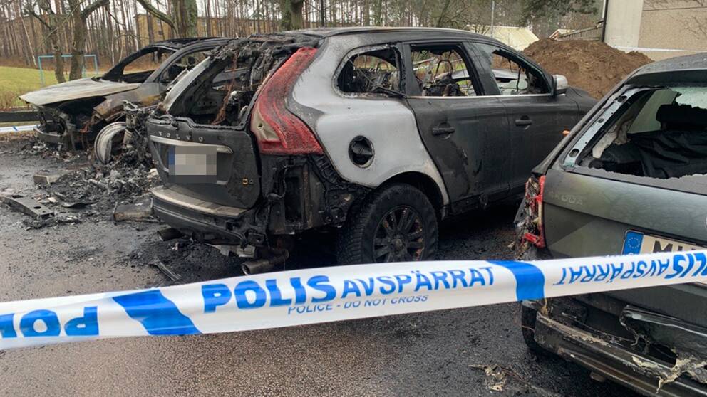 tre utrbrända bilar på en parkeringsplats