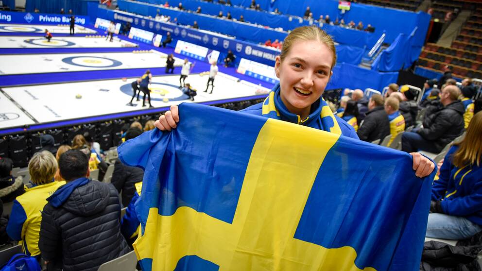 Moa Tjärnlund, åskådare, håller i en sverigeflagga på läktaren.