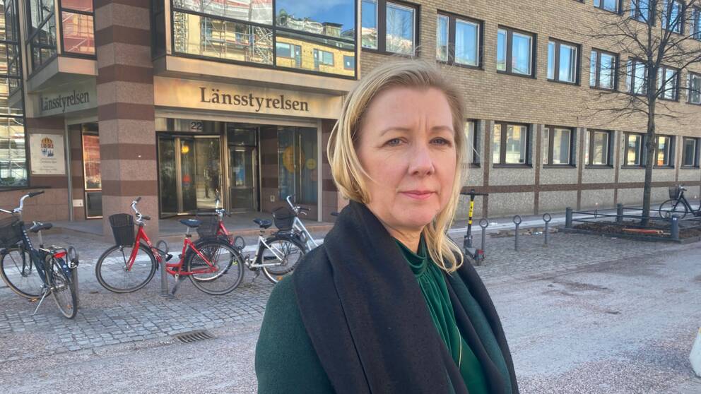 Kvinna i grön outfit som står framför Länsstyrelsens port i Örebro