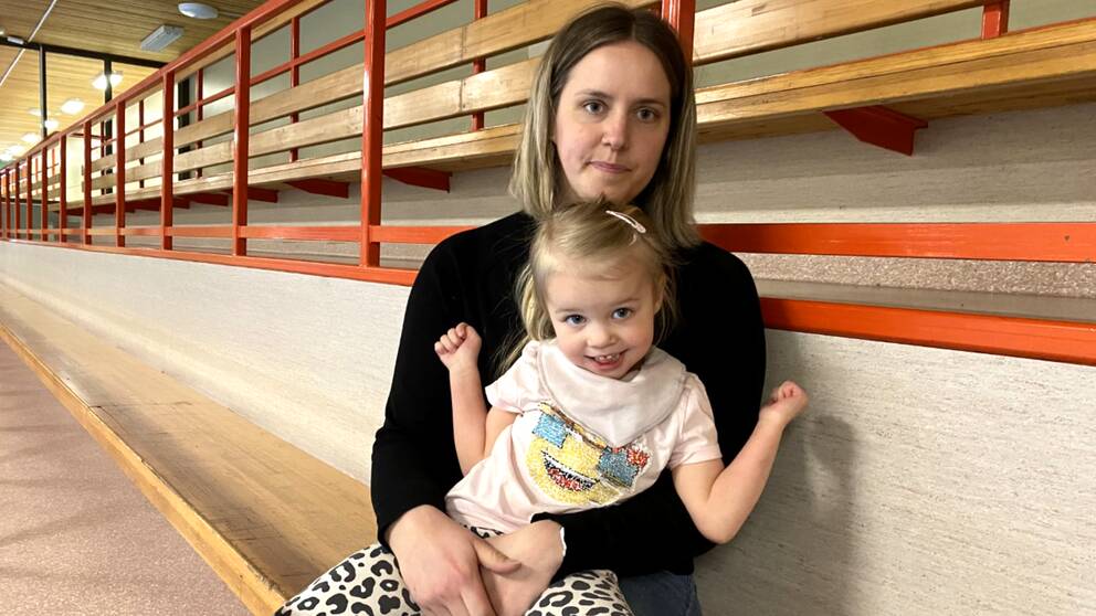 Fyraåriga Ines sitter leende i mammas knä på en läktare.