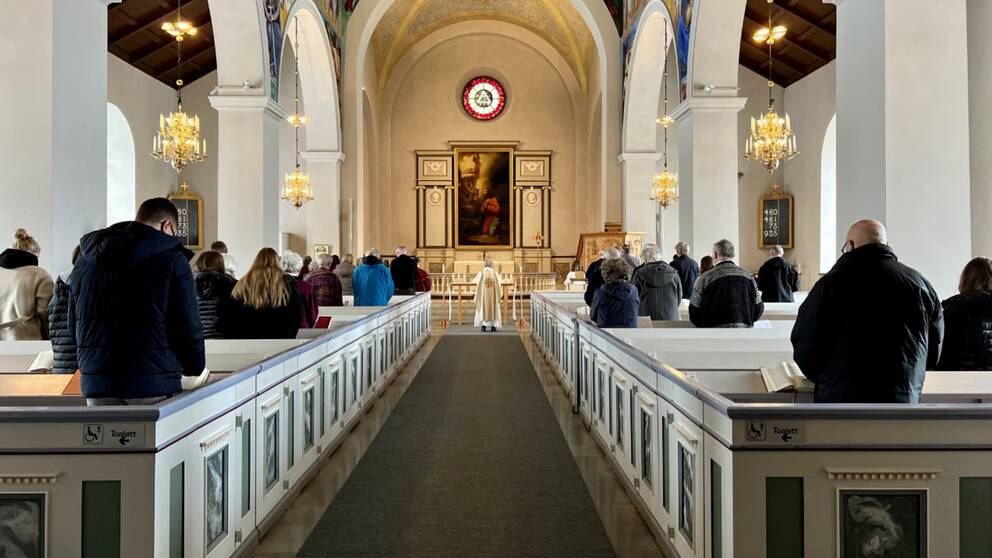 En bild längst bak inifrån Svenska kyrkan i Vetlanda under en gudstjänst.