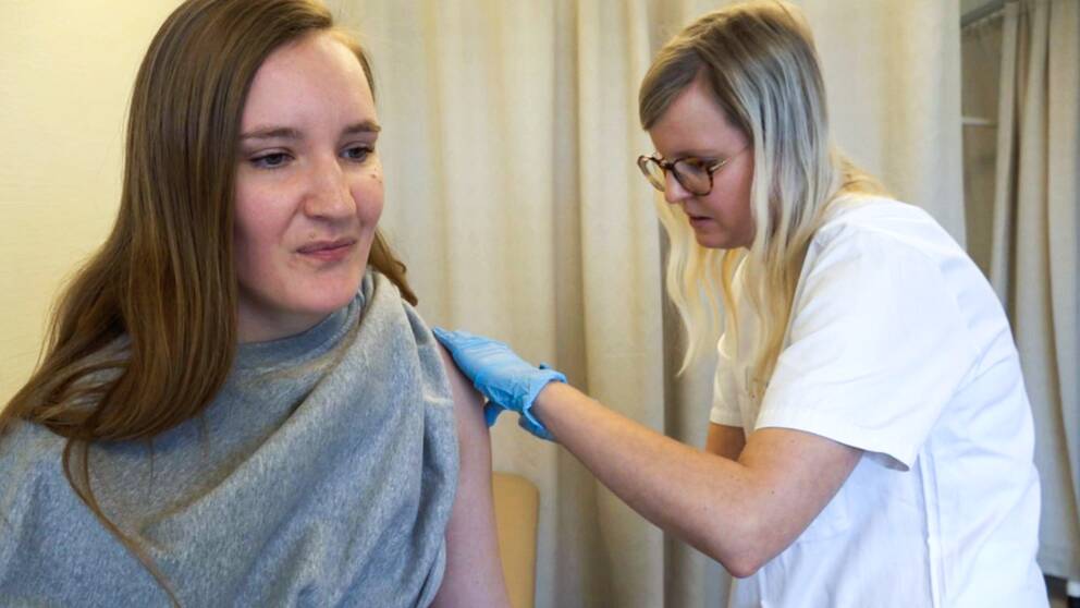 Kvinna får spruta av barnmorska. HPV-vaccin.