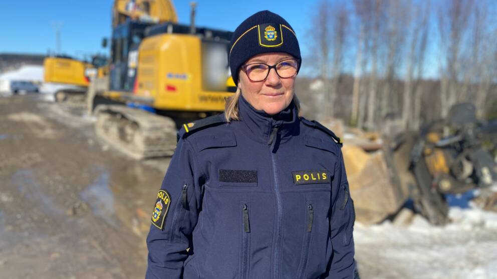 Polisen Marlene står framför en grävmaskin