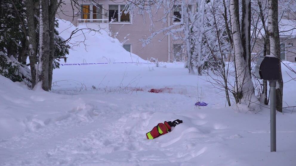 Blodstänk i snön utanför ett bostadshus i Torvalla där en kvinna hittades skadad i januari 2023.