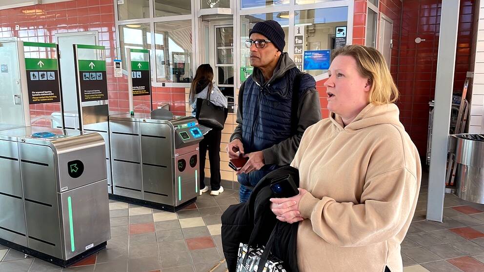 Resenärer på Kungsängens pendeltågsstation tittar på avgångstavlan