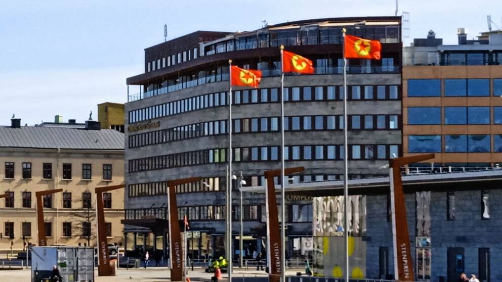 Röda flaggor med en gul cirkel och stjärnor i mitten vid stenpiren.