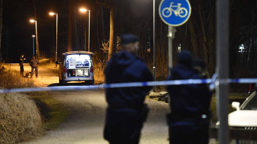 Två poliser framför en aspärrning.