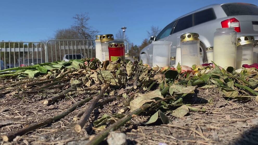 Ljuslyktor och torkade blommor. I bakgrunden syns en bil.