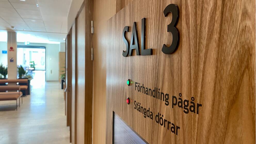 Utanför en rättegångssal ”sal 3” står på en tavla.