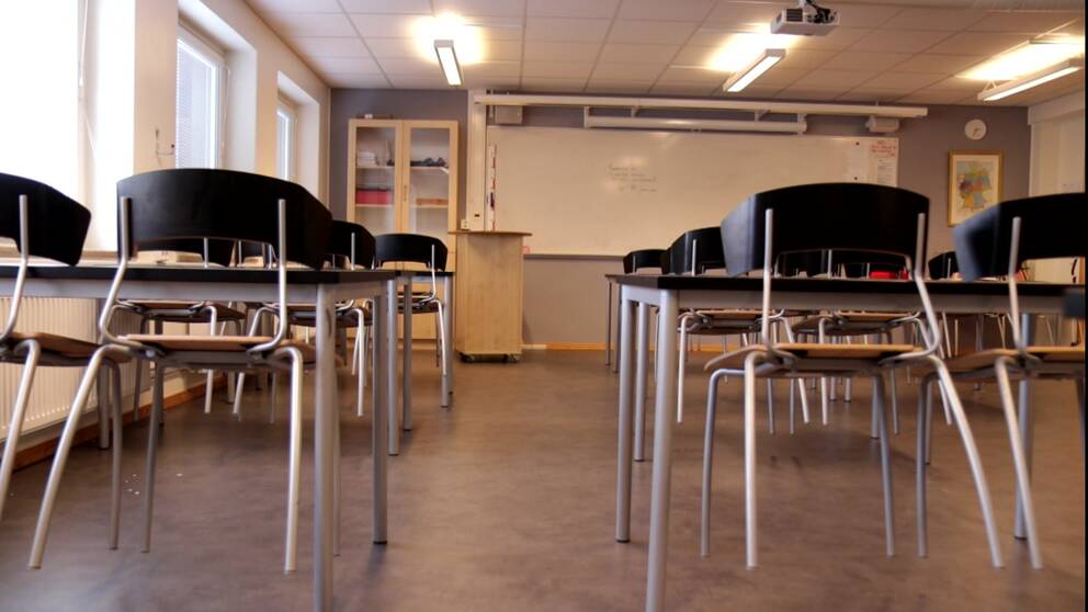 Klassrum med stolar och skolbänkar.