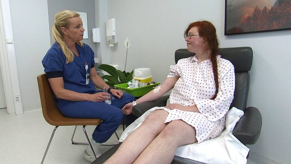 29-åriga Louise Larsson är en av de värmländska patienter som opereras i Norge. På bilden sitter hon i sjukhuskläder bredvid en läkare.