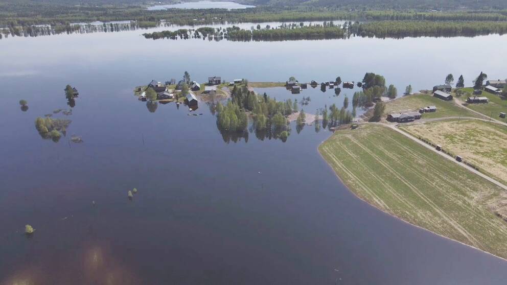 Bild tagen med drönare som visar hur vattnet svämmar över byn Jukosengi i Tornedalen.