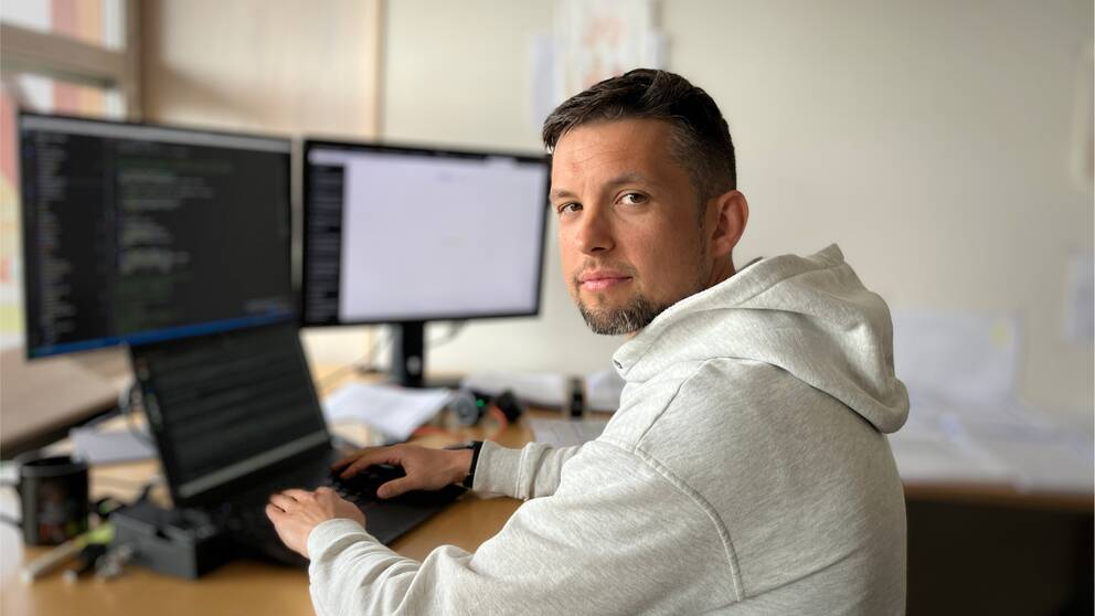 Felix Dobslaw, forskare på MIUN sitter framför dataskärmar och tittar in i kameran.