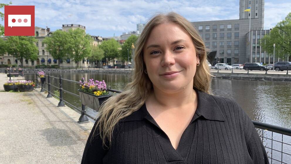 Tjej med halvlångt blont hår tittar in i kameran. I bakgrunden syns ån och stadshuset i Västerås.