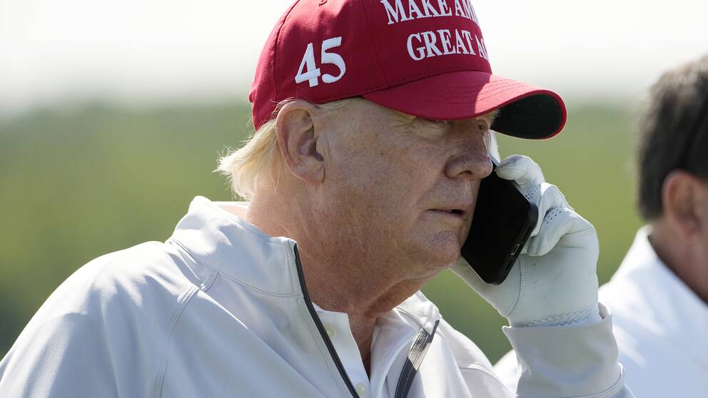 USA:s tidigare president Donald Trump håller upp en smarttelefon till örat. Arkivbild.