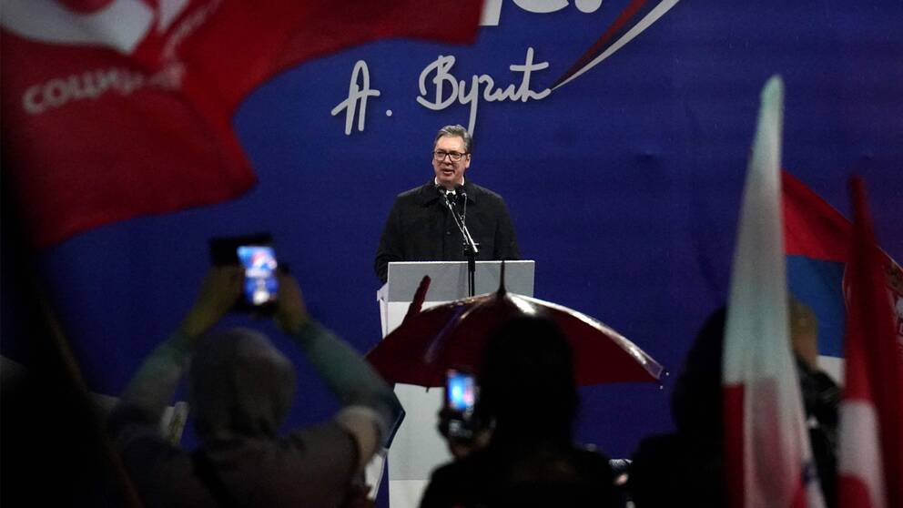 Serbiens hårt kritiserade president Aleksandar Vucic vid ett tal under en manifestation i regnet i Belgrad på fredagen.