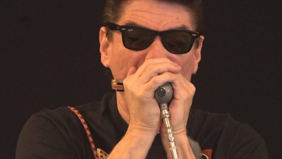 Närbild på den amerikanska bluesmusikerna Bob Corritore när han spelar elektriskt munspel.