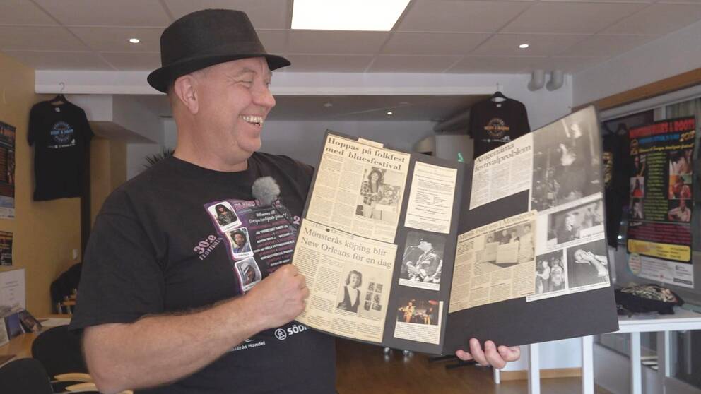 Artistansvarige Jan Aldorssons visar upp en bok med tidningsklipp från bluesfestivalens historia.