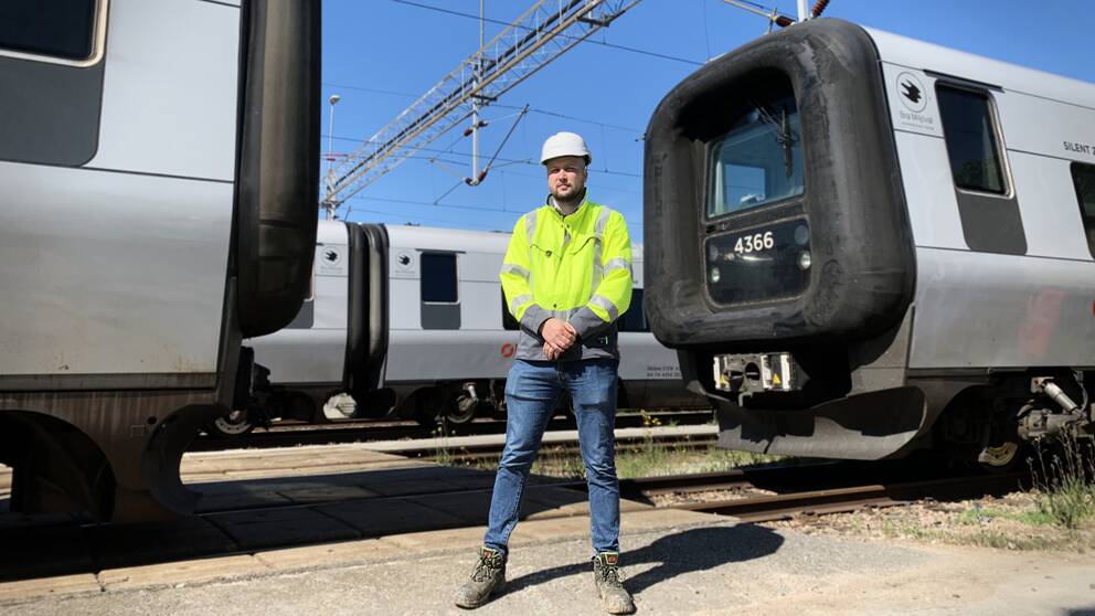 André Bjerborn från Trafikverket står mellan två tåg som står stilla och med ett tredje tåg bakom sig i Helsingborg där en ny station ska stå klar till slutet av 2023.