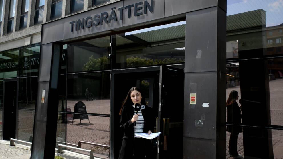 Reportern Nada Razooq – en ung kvinna med mikrofon – står framför entrén till tingsrätten i Södertälje