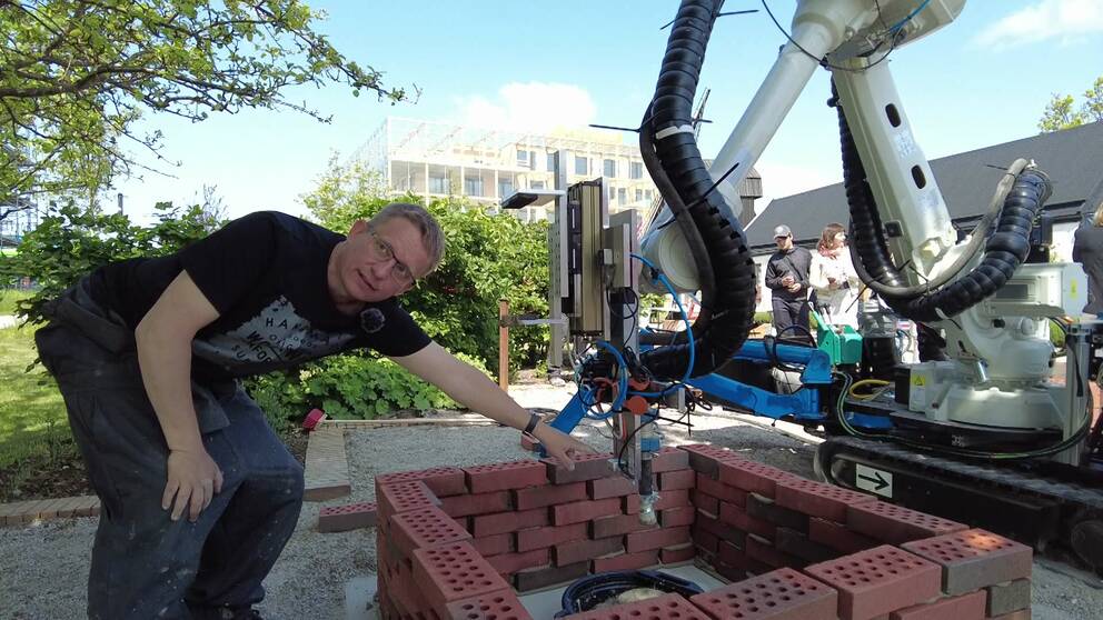 Mathias Haage, lektor i datavetenskap vid Lunds tekniska högskola, visar upp roboten ”Bettan” som murar en grillplats i Lund.