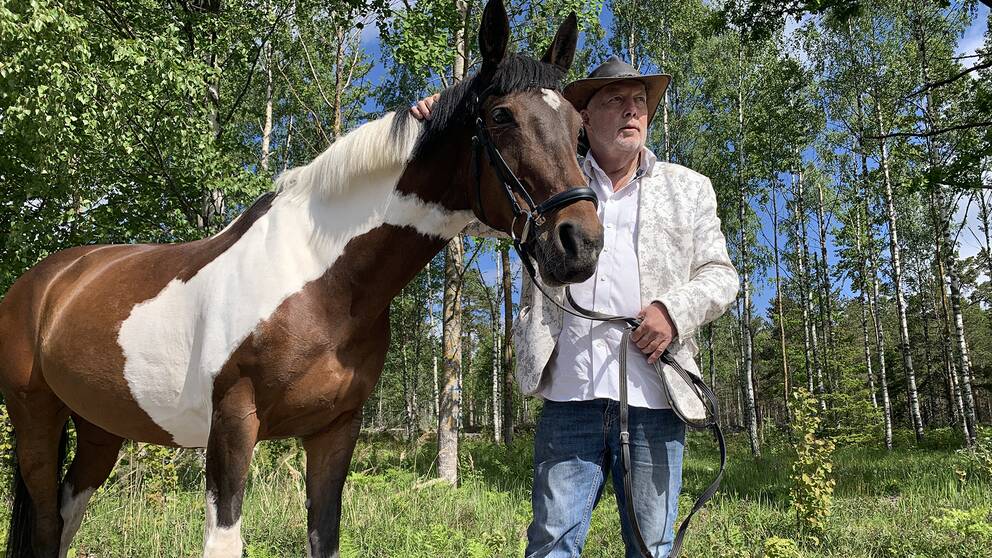 Staffan Gising med sin svartvita häst i skogen.