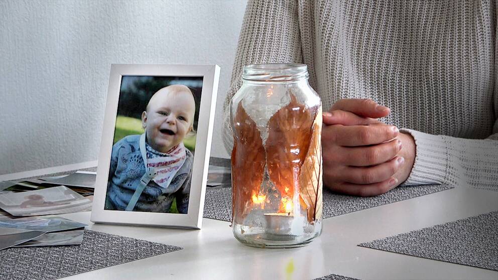 Matteos mamma sitter vid köksbordet vid en ljuslykta och en bild på sin son.