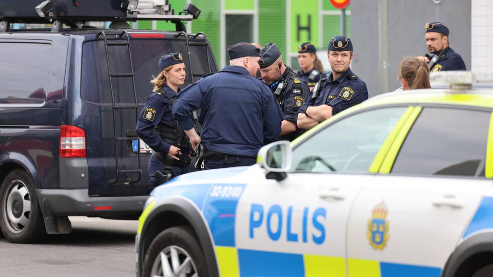 Flera poliser vid en polisbild med armarna i kors.