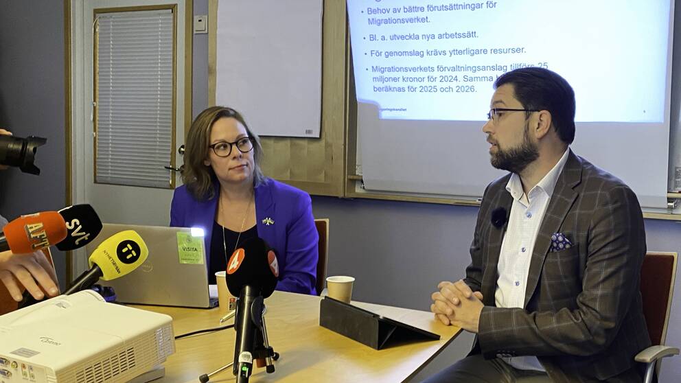 Migrationsminister, Maria Malmer Stenergard (M), och Sverigedemokraternas partiledare, Jimmie Åkesson sitter vid ett bord på en pressträff.