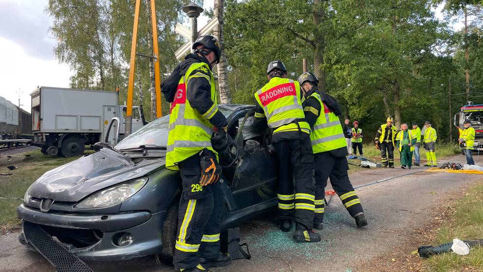 Räddningstjänsten Skåne Nordväst arbetar med att få ut skadade personer ur en krockad bil vid en iscensatt olycka vid ett tågspår.