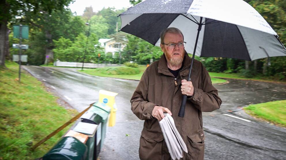 Gunnar Klasson hämtar sin tidning i regnet i Uddevalla.