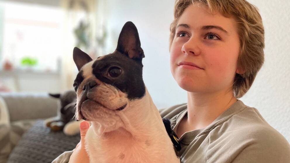 Ronja Stevelind sitter och håller sin assistanshund Baba