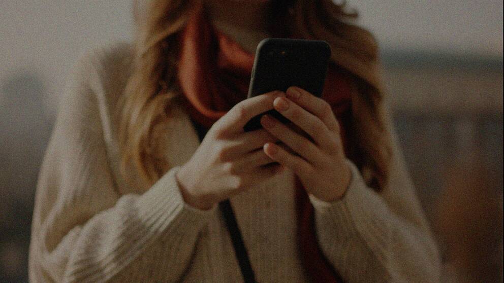 En genrebild på en person som håller i en mobiltelefon.