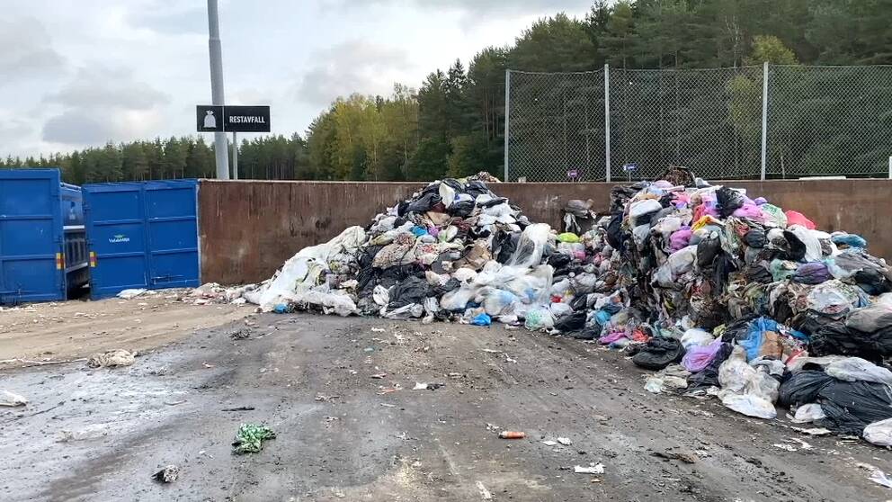 En hög med soppåsar innehållande restavfall men även matrester mellanlagras på en betongplatta inne på Sänkmossens avfallstation i Fagersta.
