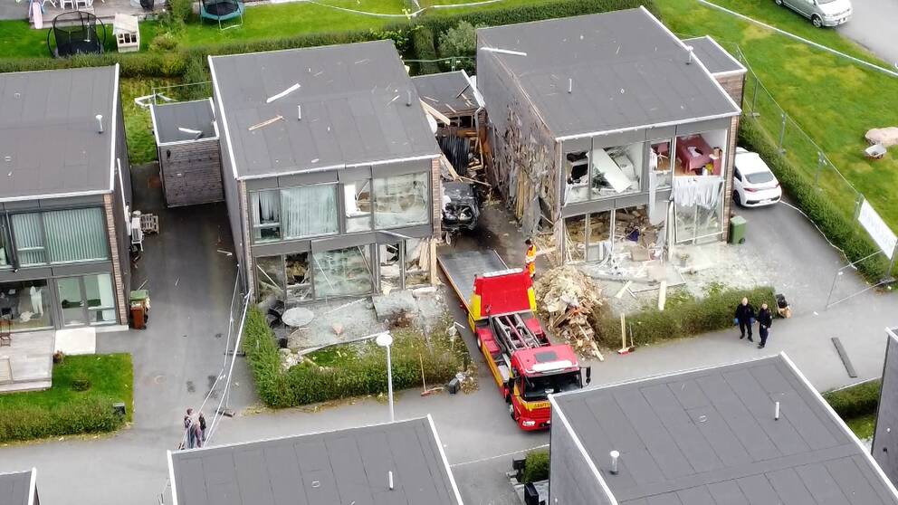 Drönarbild på två radhus som har utsatts för explosion. Polis och bärgningsbil på plats.