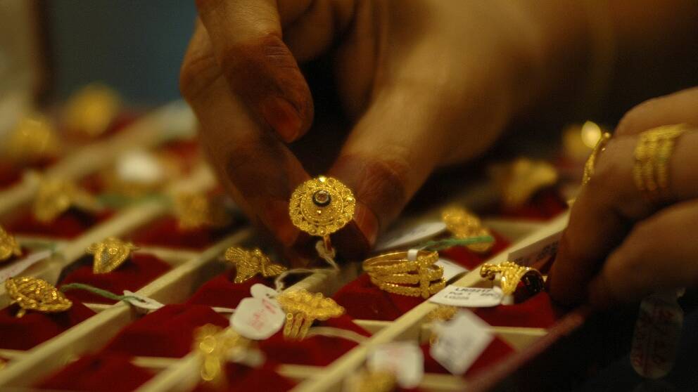 En smyckesspekulant väljer bland guldringar i indiska Gauhati, 14 mars 2008.