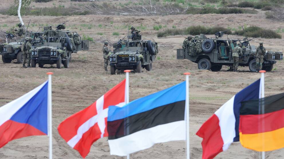 FILE – In this June 18, 2015,file photo flags wave in front of soldiers who take positions with their army vehicles during the NATO Noble Jump exercise on a training range near Swietoszow Zagan, Poland. Poland said Wednesday Feb. 3, 2016 it welcomes a U.S. plan to quadruple military spending in Europe in reaction to Russia s military resurgence, yet the tone from several governments appears guarded as it remains unclear how much of the spending will translate into a real and lasting presence of troops and weapons on NATO s nervous eastern flank. (AP Photo/Alik Keplicz)