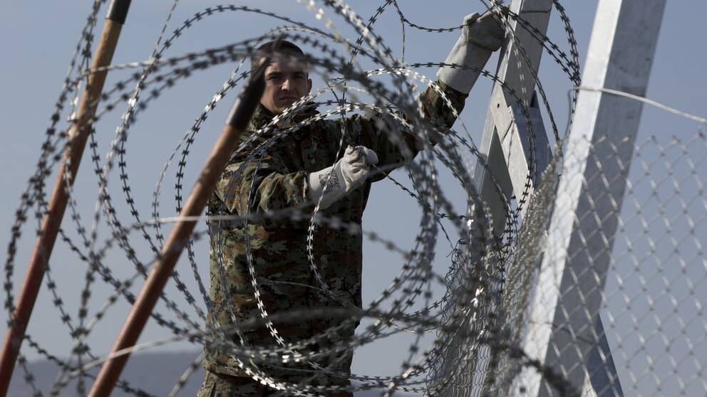 A Macedonia soldier sets up barbed wire along the border fence towards the registration camp near the southern Macedonian town of Gevgelija, Wednesday, March 2, 2016. Macedonia is restricting the entry of refugees to match the number of those leaving the country, allowing in only refugees from Syria and Iraq, in response to bottlenecks further up along the Balkans migrant route. (AP Photo/Visar Kryeziu)