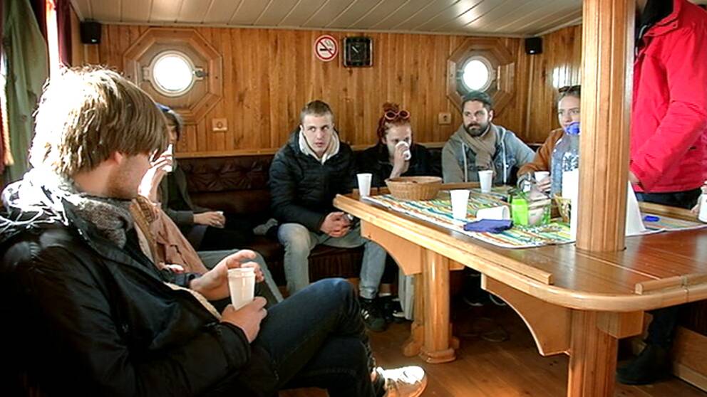 Ungdomar sitter inne i en båt vid ett bord.