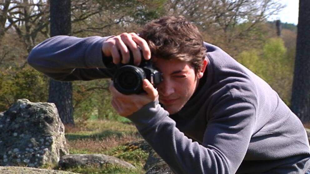 Lorenzo Bacci fotograferar stenar på gravfältet vid Hjortsberga kyrka.