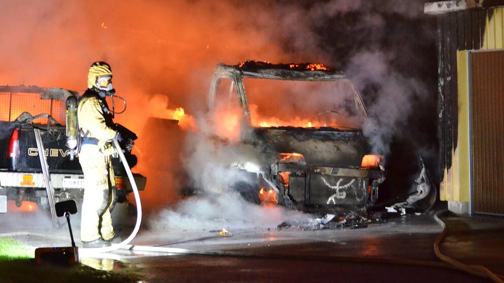 Räddningstjänst arbetar med släckning av ett av de fordon som drabbades av nattens bilbränder.