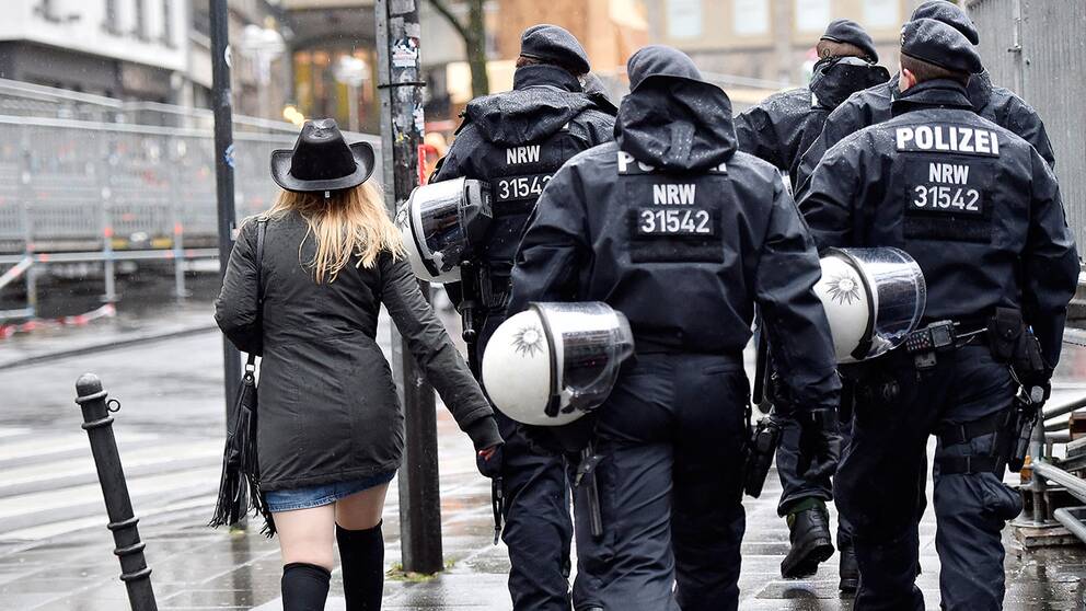 Kvinna tillsammans med poliser i Tyskland.